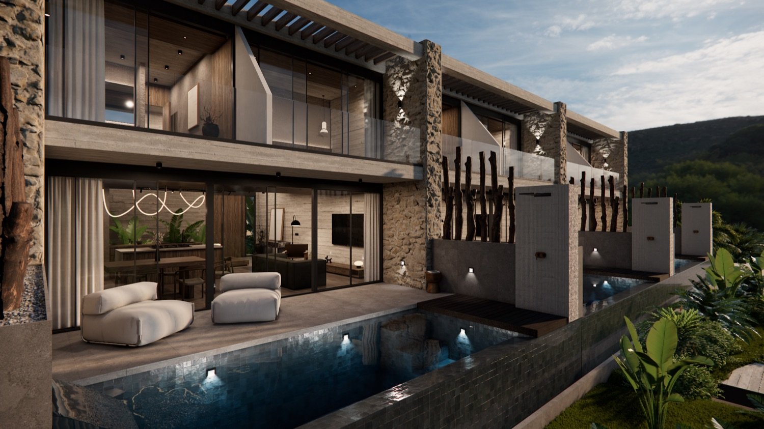 Terraced villas stepping down the hillside at dusk, a lit infinity pool and loungers before warmly glowing glass-walled interiors.